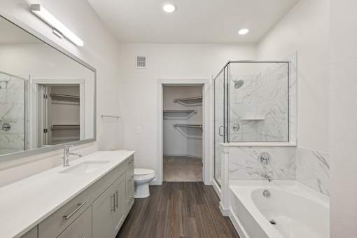 A bathroom with a white tub, sink, and toilet.