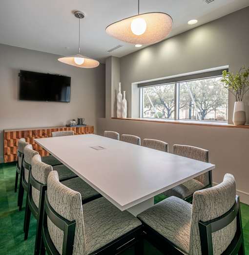A conference room with a long table and chairs.