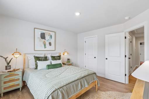 A bedroom with a bed, nightstand, and two lamps.