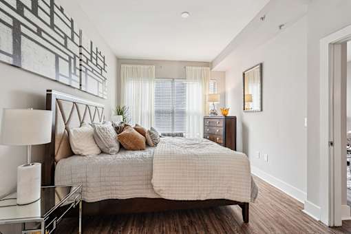 A bedroom with a large bed and a painting on the wall.