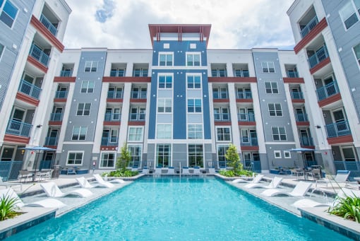 an apartment building with a large pool in front of it