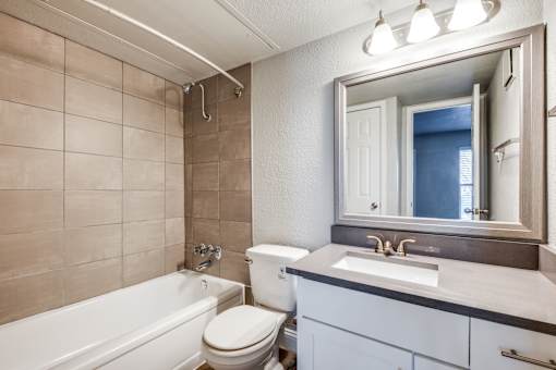 A bathroom with a white tub, toilet, and sink.