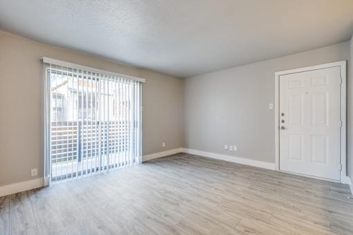 A room with a white door and a window with blinds.