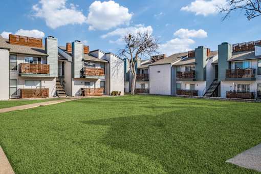 Apartment complex with green lawn in front.