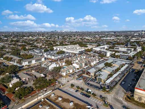 A bird's eye view of a city with buildings, roads, and cars.