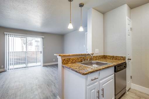 A kitchen with granite countertops and stainless steel appliances.