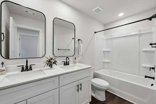 A white bathroom with a toilet, sink, and bathtub.