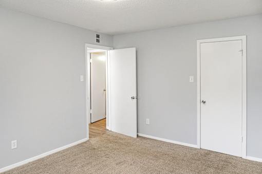 A room with two white doors and a carpeted floor.