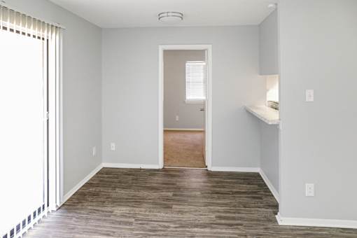 A room with wooden flooring and a window with blinds.