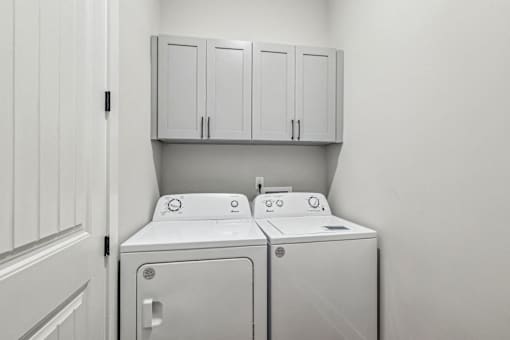 A white washing machine and dryer in a laundry room.