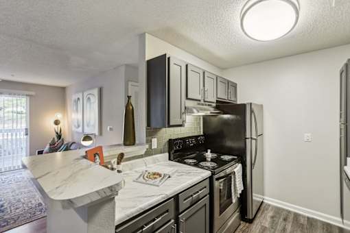 A kitchen with black appliances and a white countertop.