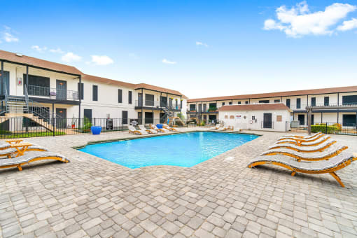 a large swimming pool in front of a group of apartments