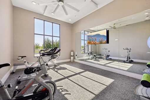 A spacious home gym with exercise equipment and a large window.