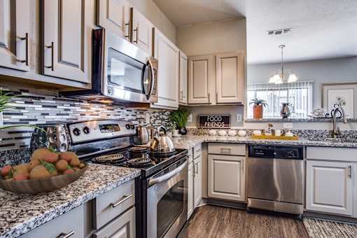 a kitchen with stainless steel appliances and marble counter tops