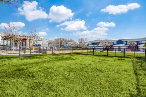 a fenced in yard with houses in the background