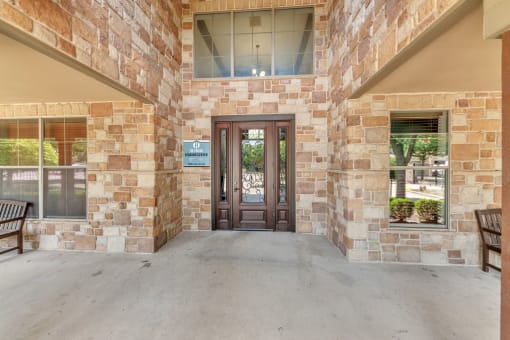 the front of the building has a wooden door and two benches