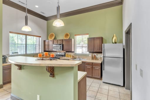 a kitchen with a large island and a stainless steel refrigerator