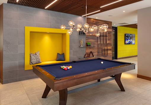 A pool table with a blue cloth and a white cue ball in the middle.