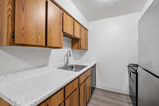 A kitchen with wooden cabinets and a granite countertop.