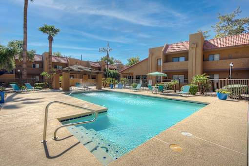 A swimming pool with a diving board in front of a building.