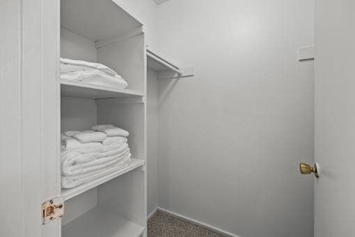A white cabinet with towels on shelves.