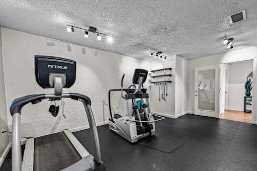 A treadmill with a TRUFIT brand label is in a room with a TRUFIT brand wall hanging.