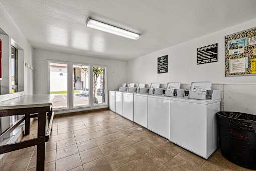 A laundromat with a row of washers and dryers.