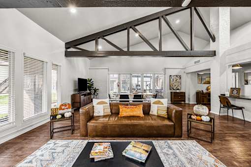 A living room with brown leather couches and a black coffee table.