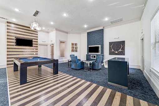 A room with a pool table and a television.