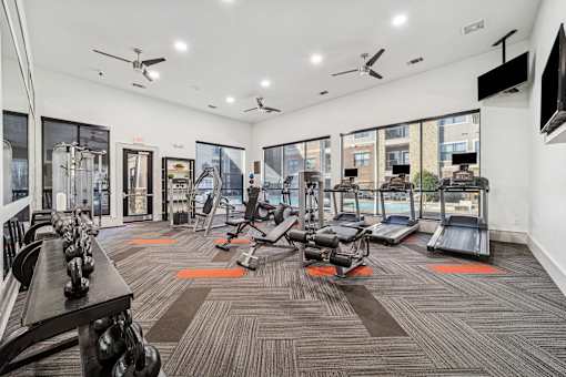 A gym with a variety of equipment including treadmills, weights, and exercise machines.