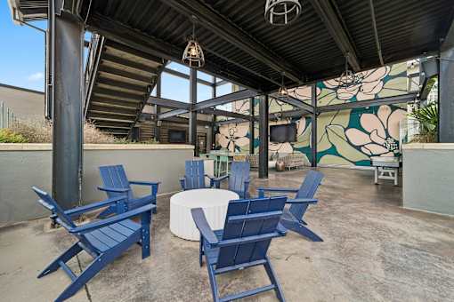A patio with blue chairs and a table.
