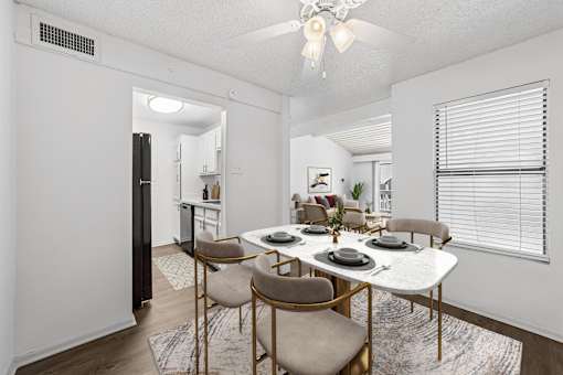 A dining room with a white table and chairs.