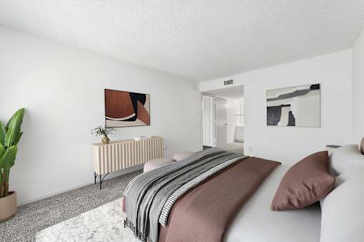 A bedroom with a bed, a radiator, and two pictures on the wall.