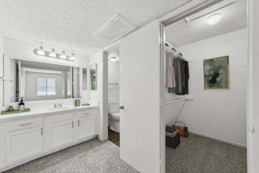 A bathroom with a white vanity and a white door.