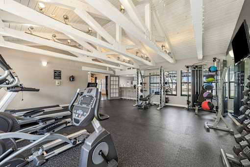A gym with treadmills, weights, and exercise equipment.