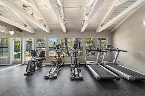 A spacious gym with treadmills, elliptical machines, and stationary bikes.