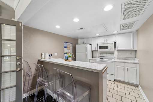 A kitchen with white cabinets and a white counter top.