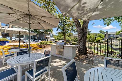 A patio with tables and chairs under umbrellas.
