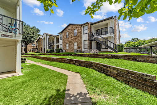 Apartment complex with a walkway in front.