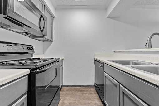 A modern kitchen with a stove, oven, and sink.