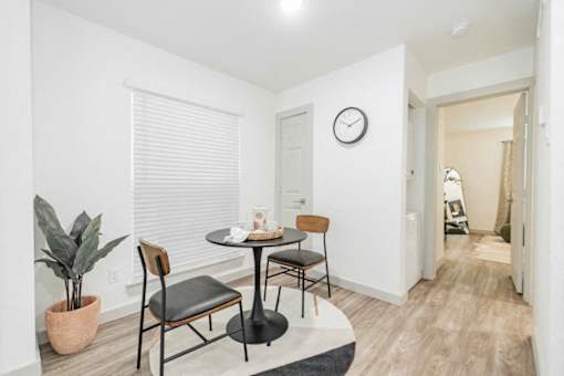 A dining room with a table and chairs.