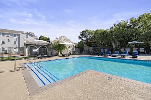 A swimming pool with a slide and a building in the background.