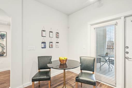 A dining room with a table and two chairs.