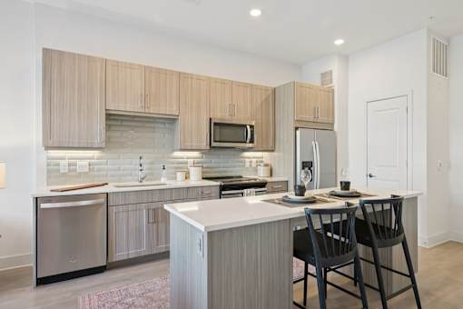A modern kitchen with a white countertop and wooden cabinets.