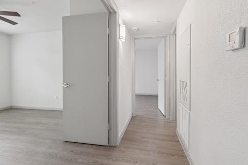 A room with a grey door and a wooden floor.