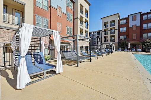 A pool area with sun loungers and a canopy.