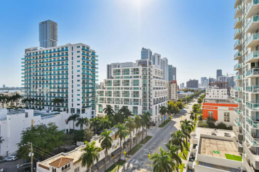 an aerial view of a city street with tall buildings and palm trees
