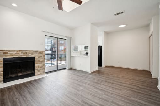a living room with a fireplace and a door to a balcony