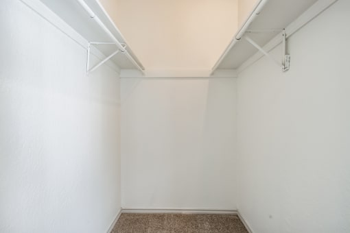 an empty room with white walls and a carpeted floor