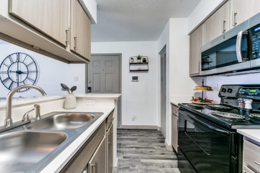 a kitchen with a sink and a stove and a microwave